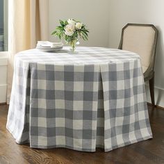 a white and black checkered table cloth on a dining room table with a vase of flowers