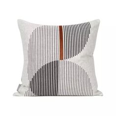 a black and white striped pillow with brown leather trim on the front, sitting against a white background