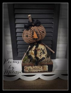 a scarecrow pumpkin sitting on top of a wooden crate in front of a window