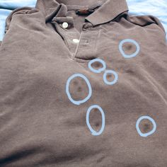 a polo shirt with circles drawn on the front and back, sitting on top of a bed