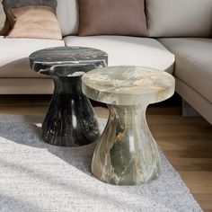 two marble tables sitting in front of a white couch