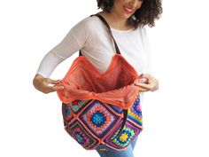 a woman holding a colorful crocheted purse