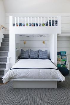 a white bed sitting under a stair case in a room with carpeted flooring