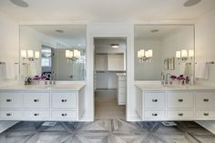 a bathroom with two sinks, mirrors and lights on the wall next to each other