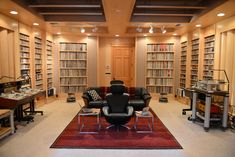 a room with many bookshelves and chairs in it