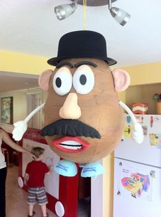 an inflatable man with a top hat and mustache is hanging from the ceiling