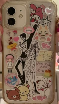 someone is holding up their phone case with many stickers on the back of it