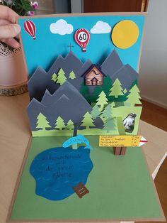 a handmade birthday card with a lake and hot air balloons