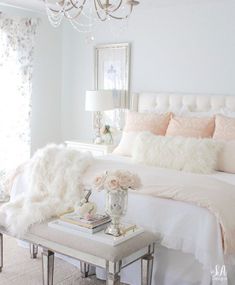 a white bedroom with pink and white decor