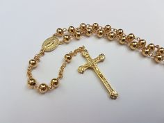 This is a handmade rosary made with entirely with 14k gold-filled material: wire, chain, beads, center, and crucifix. Where gold-plated jewelry is a very light layer of gold - 0.05% actual gold or less, US standards require the gold layer to consist of 1/20th (or 5%) of the jewelry's total weight to be considered GOLD-FILLED. This makes the rosary tarnish-resistant and keeps it shiny over years of use.  - A free velvet pouch can be replaced by a handmade 14k gold-filled-design velvet jewelry box Gold Beaded Chain Rosary, Gold Beaded Chain Rosary As Gift, Gold Rosary With Beaded Chain, Gold Rosary With Beaded Chain As Gift, Yellow Gold Rosary With Round Beads Gift, Gold Round Beads Rosary As Gift, Gold Rosary Bracelet With Cross And 8mm Beads, Gold Rosary Bracelet With Beaded Chain, Gold Beaded Chain Rosary Bracelet With Round Beads