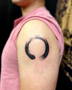 a woman with a black circle tattoo on her arm