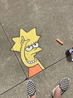 someone is standing on the sidewalk with their feet in front of a drawing of a cartoon character