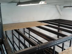 an empty room with wooden shelves and metal railings