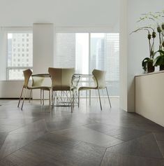 a dining room table and chairs in front of large windows