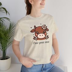 This cute T-Shirt features a lovely image of a cow with flowers and the statement "Cow goes Moo", making it a charming farmhouse animal shirt. It gives off a cozy and playful vibe, perfect for everyday wear or casual outings. Ideal for animal lovers, farmers, and those who appreciate a touch of whimsy in their wardrobe. Relevant for farm-themed parties, animal lover gifts, and casual gatherings. Product features - Made with 100% lightweight and breathable combed cotton - Retail fit suitable for casual and semi-formal settings - Manufactured in a sustainable and ethical way by Bella+Canvas - Tear-away label for added comfort - Variety of fabric blends available for different color options Care instructions - Machine wash: cold (max 30C or 90F) - Non-chlorine: bleach as needed - Tumble dry: Cow With Flowers, Farm Themed Party, Charming Farmhouse, Cute Cow, A Cow, Cute Cows, Animal Shirts, Cute Tshirts, Animal Lovers