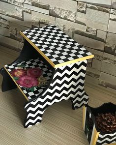 two black and white boxes sitting on top of a wooden floor next to a brick wall