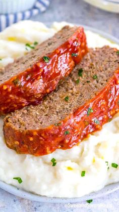 two slices of meatloaf on top of mashed potatoes