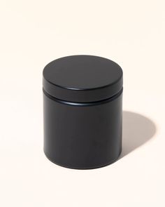 an empty black container sitting on top of a white surface