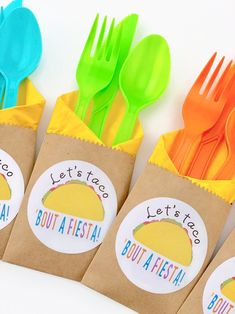 colorful plastic forks and spoons in bags with let's eat tacos stickers on them