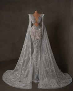 the back of a wedding dress with long sleeves and an intricate lace design on it