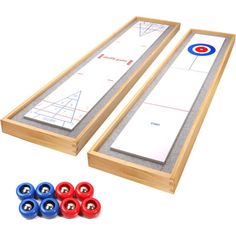 two wooden shuffle boards with six red and blue balls next to them on a white background