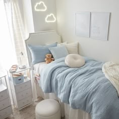 a bed with blue sheets and pillows in a bedroom