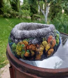 a close up of a hat sitting on top of a trash can in the grass