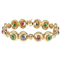 18k yellow gold bracelet. This fabulous bracelet is made up of matte finished yellow gold double "C" shaped links that are set with alternating, bezel set, oval cabachon cut, opaque to dark reddish rubies (approximately 3.24 TCW), medium navy blue sapphires (approximately 3.00 TCW) and deep green color emeralds (approximately 3.24 TCW). Alternating with the stone links are smaller, beaded links, and the clasp is a hidden box style with a figure eight safety. Marks: None, tested 18k Dimensions: 7 Cabochon Ruby, Emerald Bracelet, Ruby Emerald, Ruby Sapphire, Yellow Gold Bracelet, Lorde, Vintage Jewels, Oval Cabochon, Deep Green