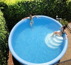 two people are swimming in an above ground pool