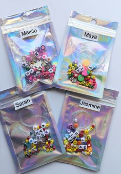 four bags filled with lots of different types of buttons and beads on top of each other