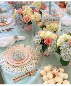 the table is set with pink, blue and white flowers