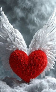 a red heart with white wings floating in the air on some fluffy, foamy clouds