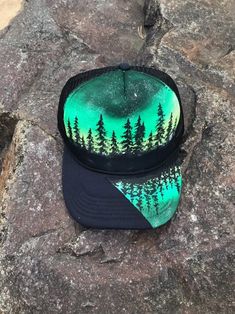 "One of a kind These are hand painted trucker hats, foam front and slight curved bill. They're made with fabric paint and sealed to protect from weather, I advise hand wash only to ensure a long life. They're adjustable SnapBack and work fo a 17-22\" head size. One of a kind! Mesh back*most hats are made to order and will differ slightly from listing photo" Custom Handmade Hats For Outdoors, Green Trucker Hat For Festivals, Custom Outdoor Snapback Hat, Artistic Hand-painted Cap, Artistic Hand Painted Cap, Hand Painted Snapback Hat, Hand Painted Adjustable Snapback Hat, Artistic Snapback Hat One Size Fits Most, Artistic Snapback Hat, One Size Fits Most