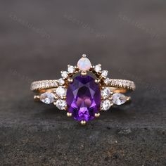 an amethorate and diamond ring on top of a stone slab with white diamonds