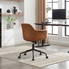 an office chair sits in front of a desk with a computer monitor and bookshelf