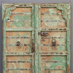 an old green wooden door with ornate carvings on the front and side panels, painted yellow