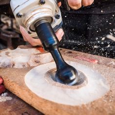 a person using a drill to cut wood