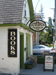 the outside of a book store with a car parked next to it