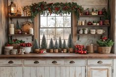 a kitchen decorated for christmas with greenery and decorations on the window sill above