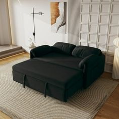 a black couch sitting on top of a rug in a living room