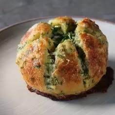 a muffin with spinach and cheese on a plate