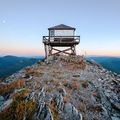 a small tower on top of a mountain with a sky in the backgroud