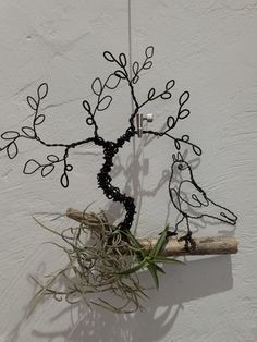 a wire tree with two birds sitting on it