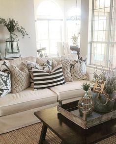 a living room filled with lots of furniture and pillows on top of a coffee table