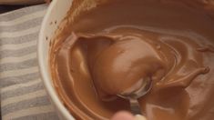 a person mixing chocolate in a white bowl