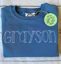 a blue shirt with the word grayson on it