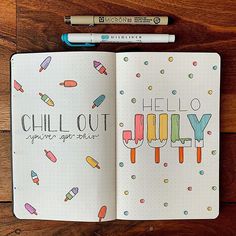 an open notebook with the words hello july written on it and some crayons next to it