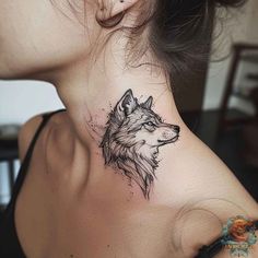 a woman's neck with a tattoo of a wolf on the back of her neck