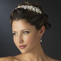 a woman wearing a bridal headpiece with pearls and crystals on the top of her hair