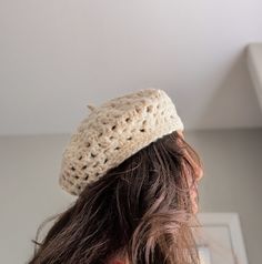 a woman with long hair wearing a crochet hat on top of her head